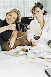 Portrait of two mid adult women toasting cups of coffee and smiling