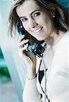 Portrait of a mid adult woman talking on a pay phone