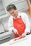 Close-up of a mature man cutting vegetables in the kitchen