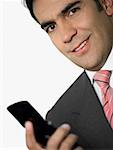 Portrait of a businessman holding a mobile phone and smiling