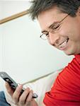 Close-up of a mature man looking at a mobile phone and smiling