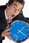 Portrait of a businessman holding a clock