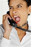Close-up of a businesswoman talking on telephone and making a face