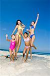 Two young women and two girls playing on the beach