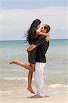 Profil de côté d'un jeune couple embrassant l'autre sur la plage