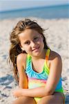 Portrait of a girl sitting on the beach and smiling