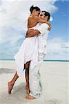 Side profile of a young couple embracing each other on the beach