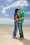 Side profile of a young couple embracing each other on the beach