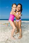 Portrait of two girls hugging each other on the beach