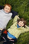 Portrait de garçons couchés dans le champ d'herbe
