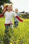 Girl and Boy Running in Field