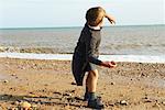 Boy Throwing Rocks at the Beach