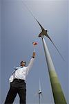 Businessman with Pinwheel by Wind Turbine