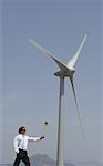 Businessman with Pinwheel by Wind Turbine