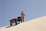 Businessman by Desk on Sand Dune