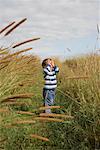 Boy in Field Covering Eyes