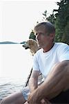 Homme à l'extérieur avec le chien, trois Mile Lake, Muskoka, Ontario, Canada