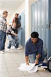 Friends Laughing at Boy Dropping Notes by Locker