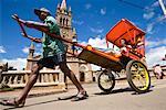 Conducteur de rickshaw avec passagers, Antsirabe, Madagascar