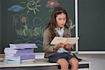 Portrait of Girl Reading Book in Classroom