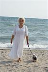 Woman Walking Dog on Beach