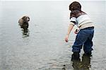 Jungen spielen mit Hund am Strand