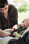 Mother Buckling Baby into Car Seat