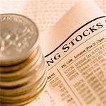 High angle view of a stack of antique coins on a financial newspaper