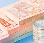 Close-up of Indian banknotes with a stack of Indian silver coins