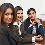 Portrait de trois femmes d'affaires assis dans une salle de conférence