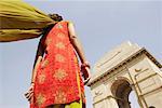 Low angle view of a woman standing in front of a monument, India Gate, New Delhi, India