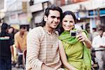 Close-up of a young couple sitting in a rickshaw and taking a photograph of themselves