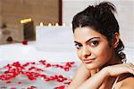 Portrait of a young woman in a bathtub and smiling