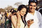 Close-up of a young couple sitting in a rickshaw and listening to an MP3 player