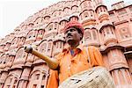 Low Angle View of ein Schlangenbeschwörer steht vor einem Palast, Hawa Mahal, Jaipur, Rajasthan, Indien