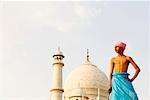 Vue d'angle faible d'un jeune homme debout devant un mausolée, Taj Mahal, Agra, Uttar Pradesh, Inde