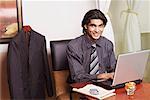 Portrait d'un homme d'affaires assis dans un bureau et à l'aide d'un ordinateur portable