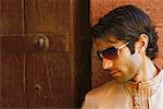 Close-up of a young man standing in front of a wooden door, Agra Fort, Agra, Uttar Pradesh, India