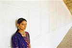 Portrait of a young woman leaning against a wall and smiling, Agra Fort, Agra, Uttar Pradesh, India