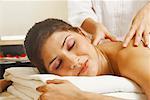 Close-up of a young woman getting a shoulder massage from a massage therapist