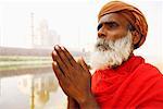 Close-up of a priest standing in a prayer position on the riverbank, Taj Mahal, Agra, Uttar Pradesh, India