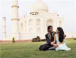 Jeune couple assis en face d'un mausolée, Taj Mahal, Agra, Uttar Pradesh, Inde