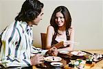 Gros plan d'un jeune couple s'asseoir et de parler à la table à manger