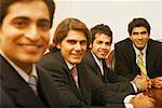 Portrait de quatre hommes d'affaires, assis dans une salle de conférence