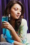 Close-up of a young woman holding a glass of cocktail