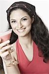 Portrait d'une jeune femme tenant un verre de martini