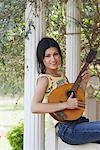 Portrait of a young woman holding a mandolin