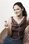 Porträt einer jungen Frau, die einen MP3-Player anhören