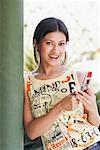 Portrait of a young woman holding a mobile phone and smiling