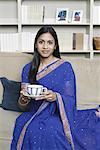 Portrait of a young woman holding a cup of tea